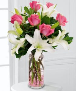 Delight her senses when you send this fragrant bouquet of roses, lilies and eucalyptus in a wire wrapped decorative vase!